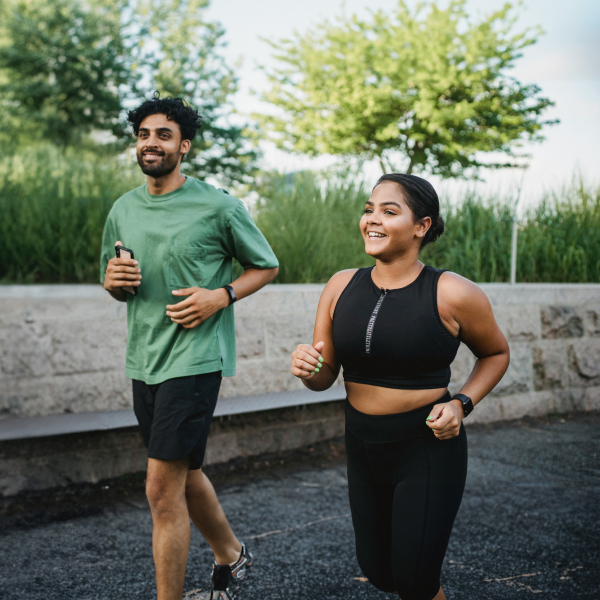 Man and woman jogging outdoors as part of an exercise routine to help improve cholesterol levels