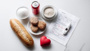 Foods high in sugar and refined carbohydrates alongside a blood test sheet representing common causes of high triglycerides